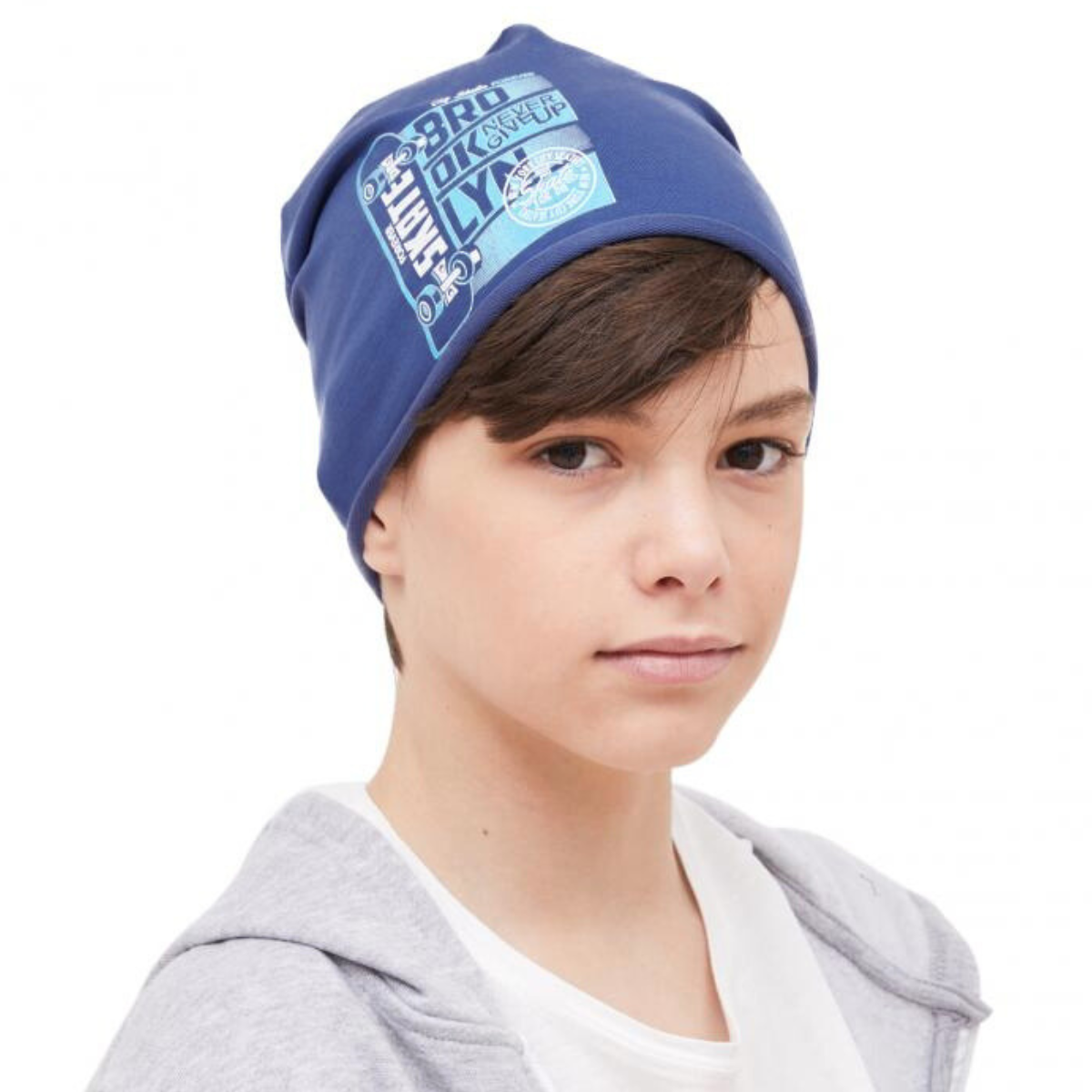 Boy wearing a blue slouchy cotton beanie with Brooklyn skateboard print, size 54–56  